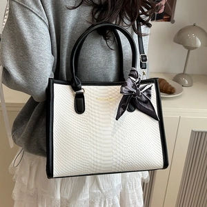 White crocodile pattern tote bag with black handles and a printed decorative scarf