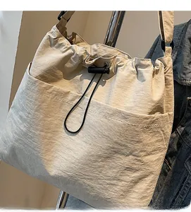 Close-up of lightweight off-white drawstring bucket bag with drawstring and nylon texture