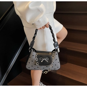 Detail of grey wool shoulder bag with black polka dots and silver bow buckle