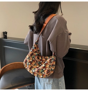 Detail of bohemian canvas tote bag showing colorful geometric knit pattern and orange strap