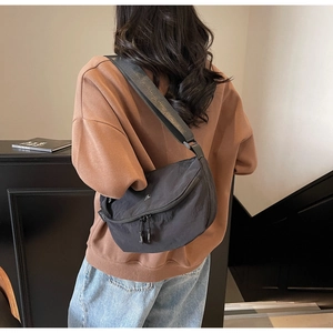 Borsa a tracolla a mezzaluna grigio scuro indossata sulla schiena con tracolla regolabile