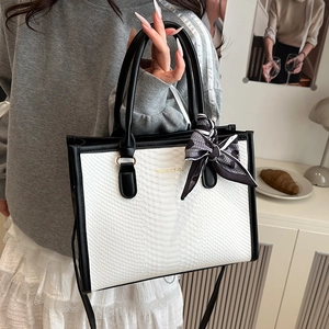 Elegant black and white snakeskin tote bag with silk scarf handle and crossbody strap