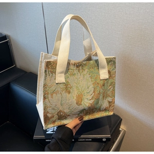 Detail of floral jacquard linen handbag with magnetic snap closure and woven handles