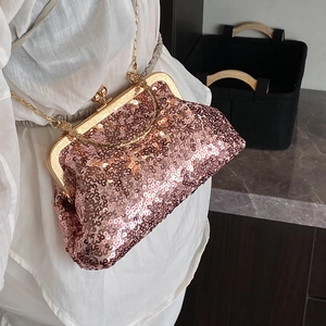 Rose gold sequined evening bag with metallic handle and chain strap worn by a model