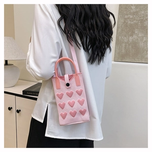 Detailed macro view of pink knitted crossbody bag featuring nine 3D heart-shaped decorations