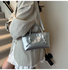 Vue détaillée du sac cabas argenté avec lettrage mode et décoration de poignée nouée