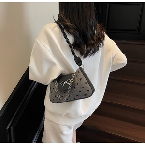Polka dot gray tweed underarm bag with flower metal chain detail shown on shoulder