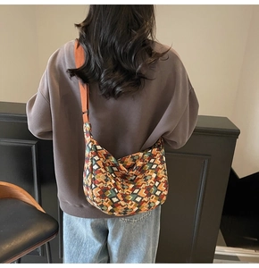 Detailed view of bohemian canvas crossbody bag with colorful geometric patterns and orange strap