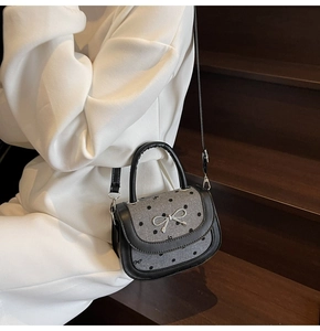 Detail shot of the vintage grey bow bag with black polka dots and silver metal buckle