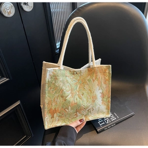 Detail of floral jacquard tote bag with white cotton rope handles and gold snap button