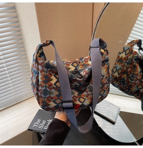 Detail of colorful geometric jacquard pattern and adjustable nylon strap on a tote bag