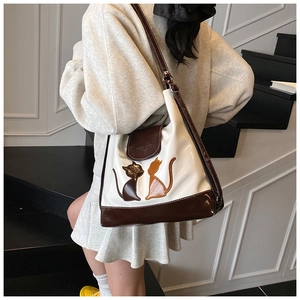 Détail d'un grand sac cabas avec silhouettes de chats porté par un mannequin en vue