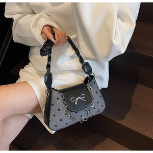 Close-up of grey felt polka dot shoulder bag with silver bow and floral chain detail