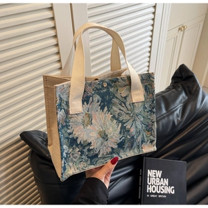 Detail of floral tapestry tote bag with canvas handles and secure metal snap closure