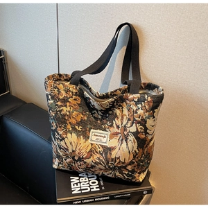 Close-up of retro woven tote bag with daisy floral texture and black fabric handles