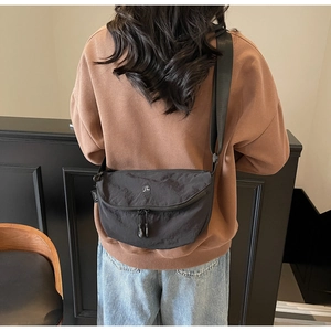 Dettaglio posteriore della borsa a mezzaluna in nylon nero con ampia tracolla regolabile