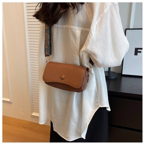 Brown litchi leather crossbody bag detail featuring ethnic print wide fabric strap