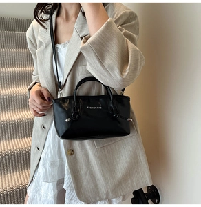 Détail du grand cabas noir en cuir avec texte Fashion Bag et nœud décoratif