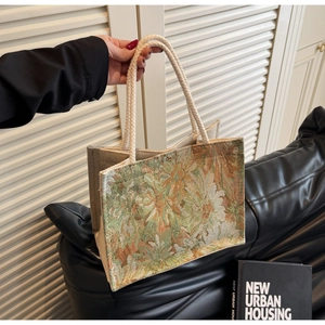 Close-up of floral jacquard fabric and cotton rope handles on a retro tote bag