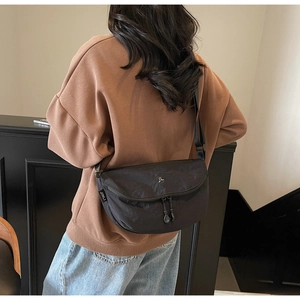 Dettaglio della borsa a tracolla in nylon a mezzaluna con logo e tracolla regolabile