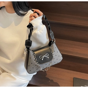 Detail of vintage grey underarm bag with black heart dots and silver bow clasp