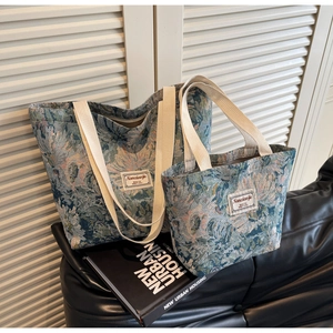 Detail of floral jacquard tote bag set with fabric logo label and woven straps