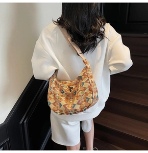 Lifestyle shot of a bohemian canvas crossbody bag with colorful pixel pattern and wide strap