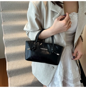 Détail du sac cabas noir avec embouts de cordon argentés et logo sur le devant
