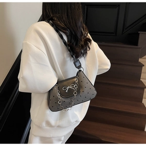 Gray heart pattern shoulder bag with silver bow detail and metallic petal chain on model