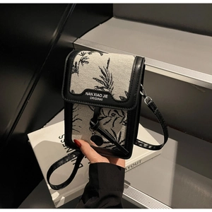 Detailed shot of retro canvas mini crossbody bag with leaf print and leather trim