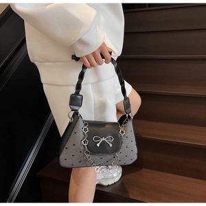 Detail of canvas bag with heart print, silver butterfly bow and braided handle