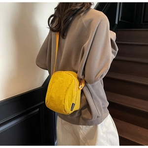 Gros plan du mini sac bandoulière en nylon jaune vif avec bandoulière réglable et logo
