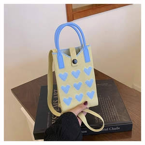 Close-up of heart patterned knitted handbag with blue hearts and magnetic closure