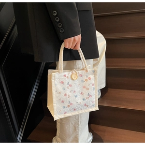 Detailed shot of floral embroidered lace handbag with cotton rope handle on wooden stairs