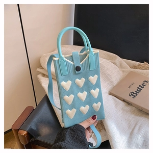 Detailed knit texture of light blue mini phone bag with white hearts and top handle