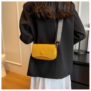 Detail of yellow lychee leather bag with colorful ethnic geometric wide shoulder strap