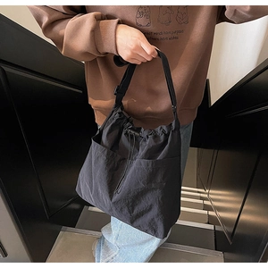 Macro shot of durable black drawstring bucket bag with large utility pockets and adjustable strap