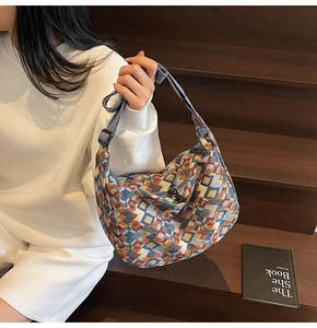 Detail of colorful geometric pattern woven tote with adjustable blue nylon strap