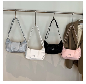 Détail de quatre sacs hobo avec nœuds métalliques en gris blanc noir et rose pastel chic
