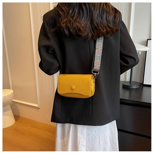 Detail of yellow pebbled leather crossbody bag with ethnic geometric wide strap