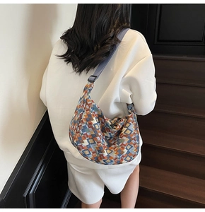 Detail of colorful geometric pattern and blue adjustable wide strap on canvas hobo bag
