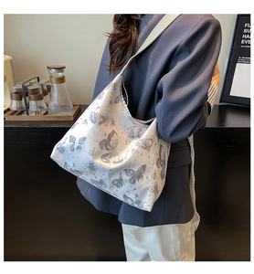 Dettaglio della grande borsa tote bianca con stampa di farfalle viola e stelle