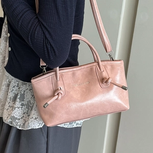 Grand sac cabas rose avec poignée nouée et bandoulière porté par un mannequin
