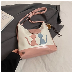 Détail du sac fourre-tout patchwork rose et blanc avec appliques de chat et breloque pompon
