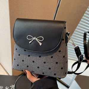 Chic polka dot bucket bag with metallic bow and adjustable leather strap