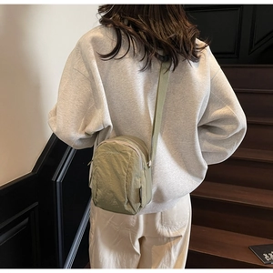 Vue détaillée d'un sac bandoulière en nylon vert olive avec sangle réglable