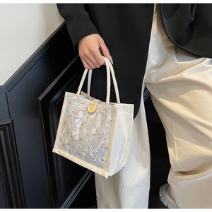 Detailed texture of lace fabric and floral canvas bag with woven handle and wood button