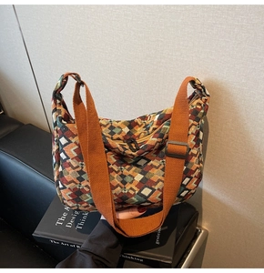 Detail of bohemian jacquard woven tote bag with colorful geometric patterns and orange strap