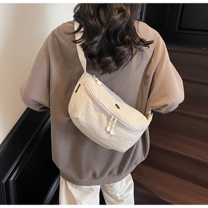 Dettaglio della borsa a tracolla beige in nylon con logo JL nero e tracolla larga