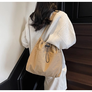 Rear view of khaki nylon drawstring bucket bag on model for casual daily commuting style